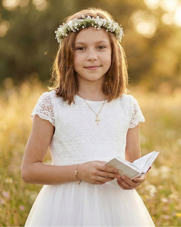 Mädchen mit Blumenkranz trägt Kinderschmuck der Aurevini-Kollektion