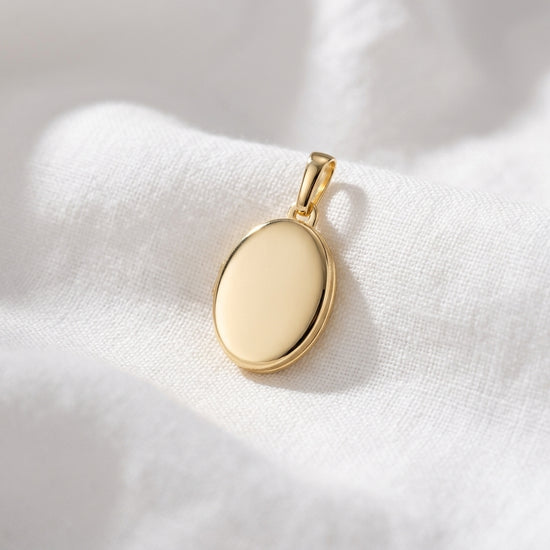 Goldenes Oval-Medaillon auf weißem Stoff, polierte Oberfläche mit klassischem Bügel zum Öffnen