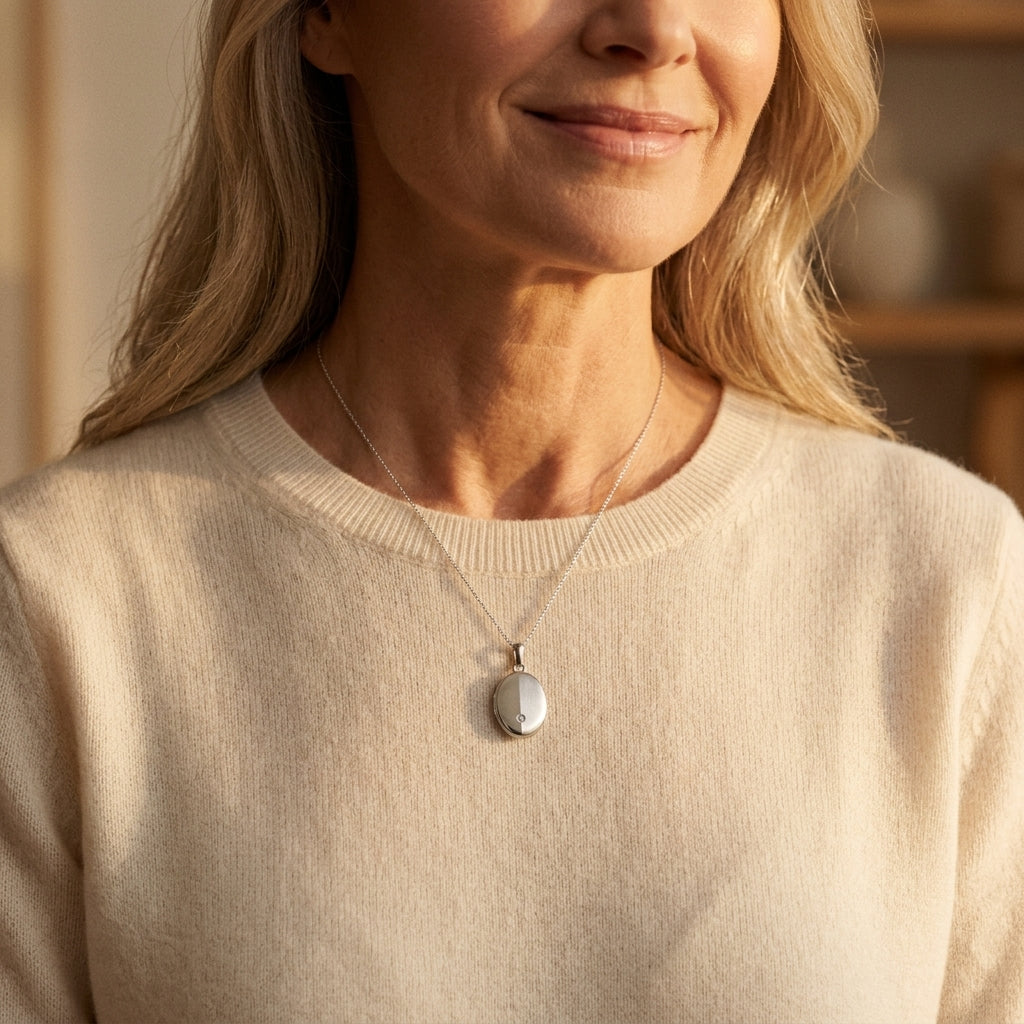 Frau trägt silbernes Medaillon Moon mit Zirkonia an zarter Kette, Aurevia Manufaktur, beiger Pullover