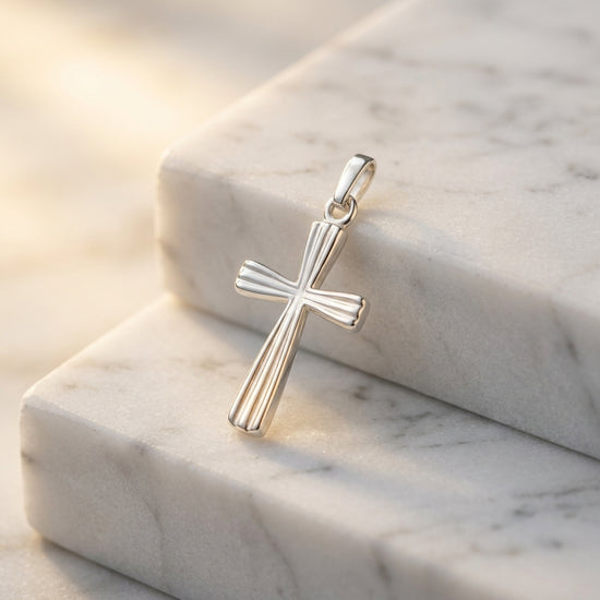 Silberner Kreuz-Anhänger Aura mit gerillter Oberfläche auf weißem Marmor, handgefertigt aus 925er Sterlingsilber