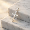 Silberner Kreuz-Anhänger Aura mit gerillter Oberfläche auf weißem Marmor, handgefertigt aus 925er Sterlingsilber