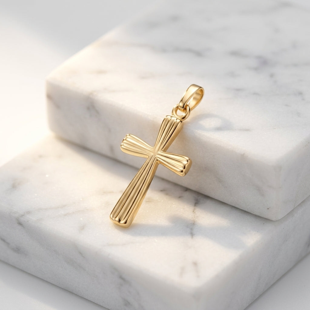 Goldener Kreuz-Anhänger mit gerillter Oberfläche auf weißem Marmor, handgefertigt aus 585er Gelbgold