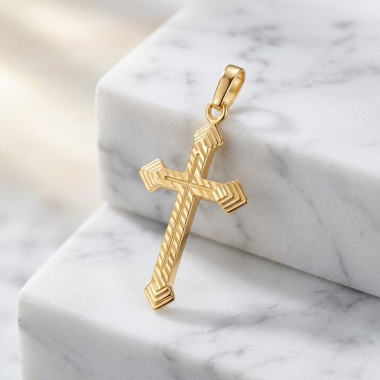 Goldener Kreuz-Anhänger Grace mit diagonaler Rillengravur auf weißem Marmor, handgefertigt aus 585er Gelbgold