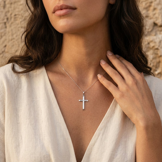 Frau trägt silbernen Kreuz-Anhänger Parallel an feiner Kette, minimalistisches Design aus Edelmetall