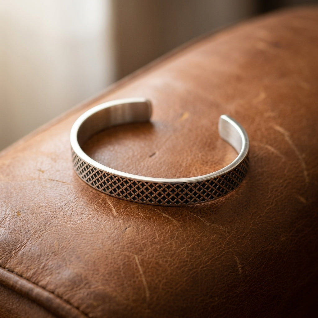 Silberne Armspange mit feinem Mesh-Gittermuster auf braunem Leder, offene Cuff-Form, handgefertigt von Aurevia