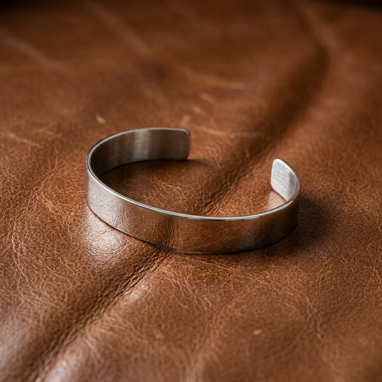 Silberne Armspange Mission als offener Cuff auf braunem Leder, handgefertigt aus massivem Sterlingsilber mit matter Oberfläch