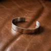 Silberne Armspange Mission als offener Cuff auf braunem Leder, handgefertigt aus massivem Sterlingsilber mit matter Oberfläch