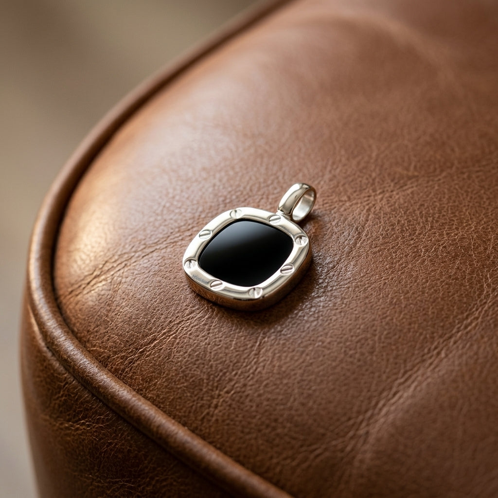 Silberner Anhänger mit schwarzem Onyx in Schrauben-Design auf braunem Leder