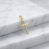 Goldener Kreuz-Anhänger Eternal mit strukturierten Enden auf weißem Marmor, hochglanzpoliert mit Öse