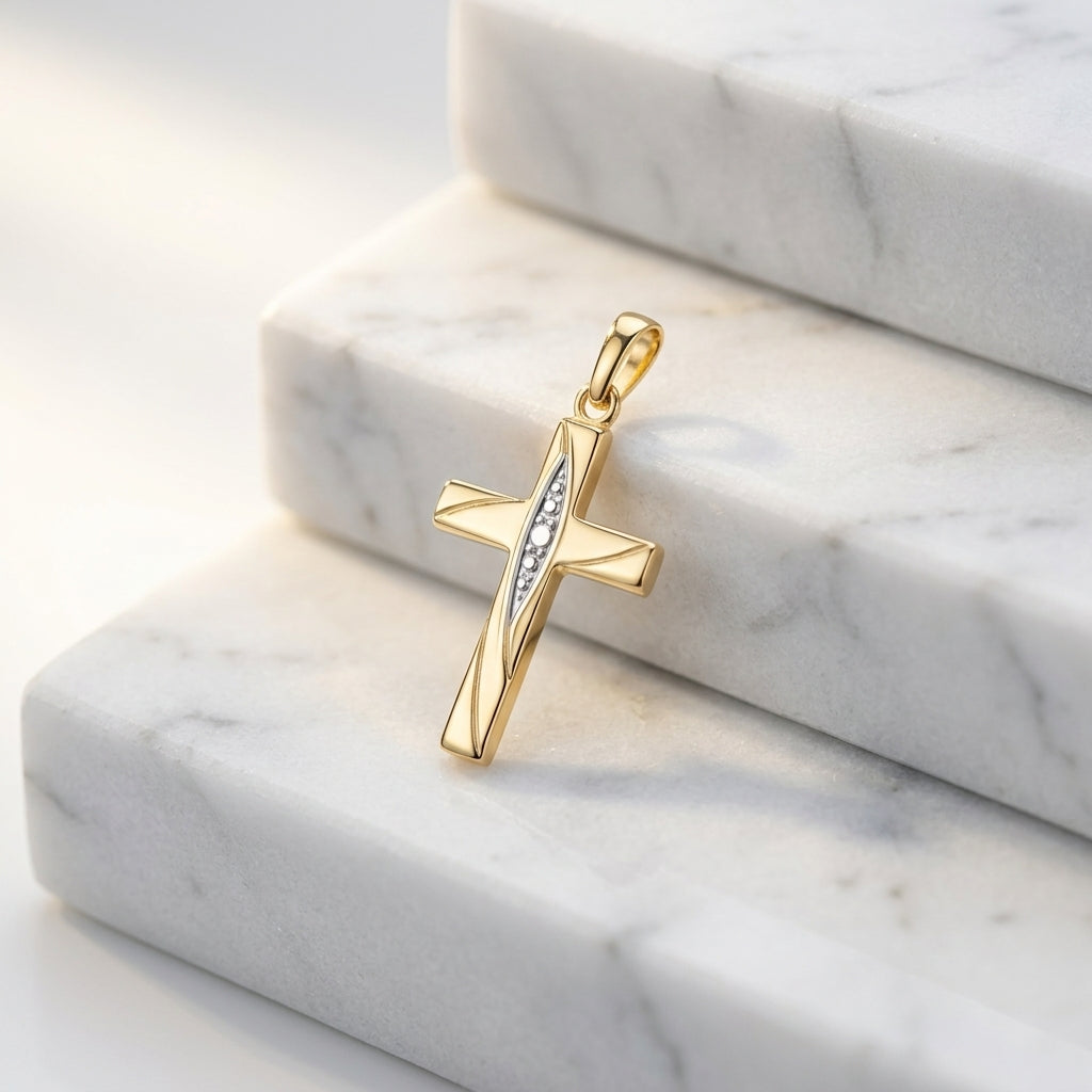 Goldener Kreuz-Anhänger Flow mit diagonalem Zirkonia-Band auf weißen Marmorstufen