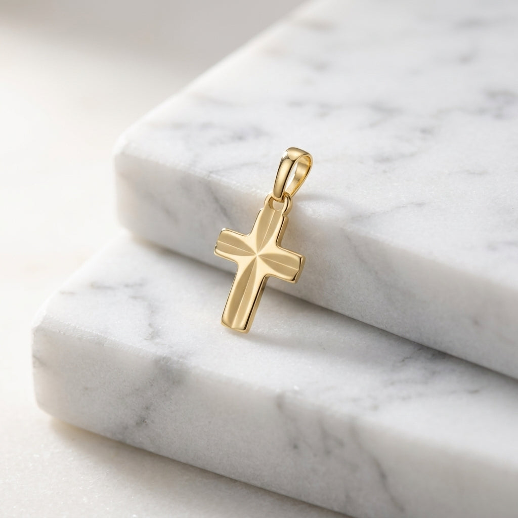 Goldener Kreuz-Anhänger Guardian mit Starburst-Muster auf weißem Marmor, poliertes Gelbgold, kleine filigrane Form