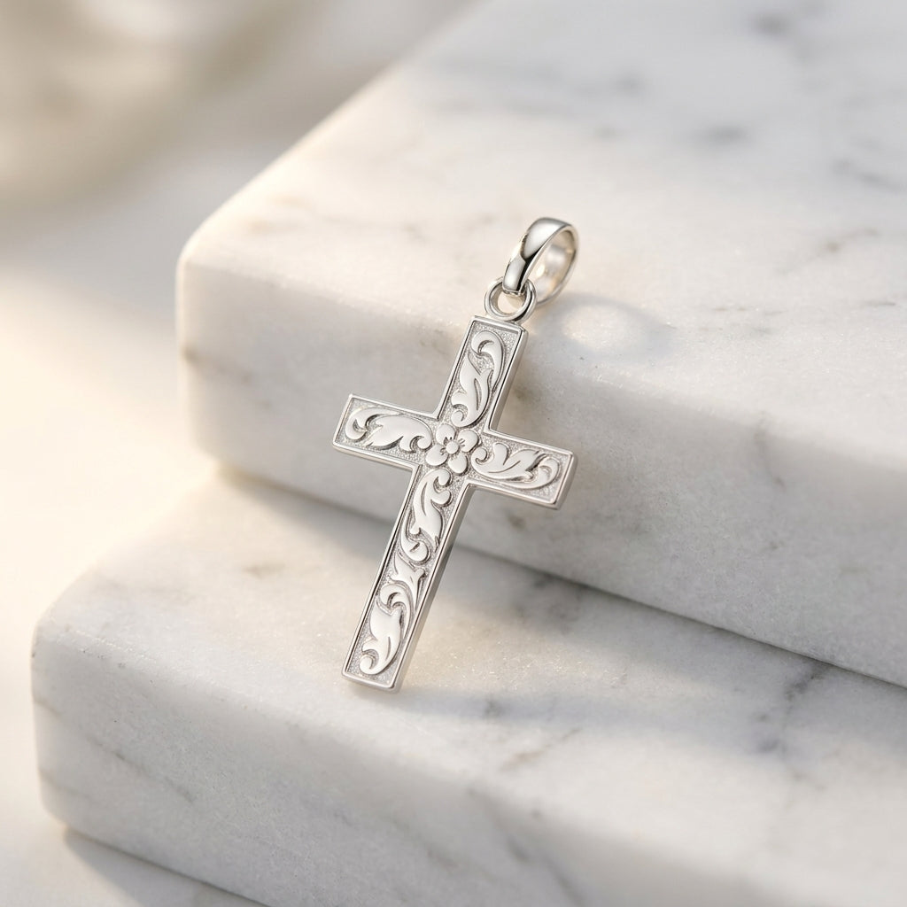 Silberner Kreuz-Anhänger mit filigranen Rankenmustern auf weißem Marmor, handgefertigt aus 925er Sterlingsilber