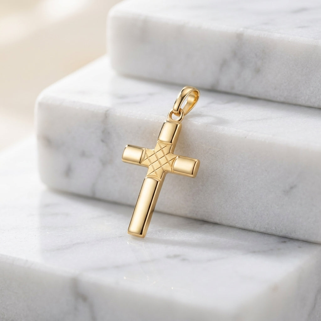 Goldener Kreuz-Anhänger Sanctum mit diamantiertem Muster im Zentrum auf weißem Marmor