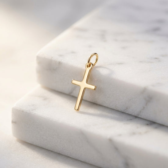 Goldener Kreuz-Anhänger Spirit auf weißem Marmor, minimalistisches Design mit Öse, aus echtem Gold gefertigt