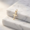 Goldener Kreuz-Anhänger Spirit auf weißem Marmor, minimalistisches Design mit Öse, aus echtem Gold gefertigt