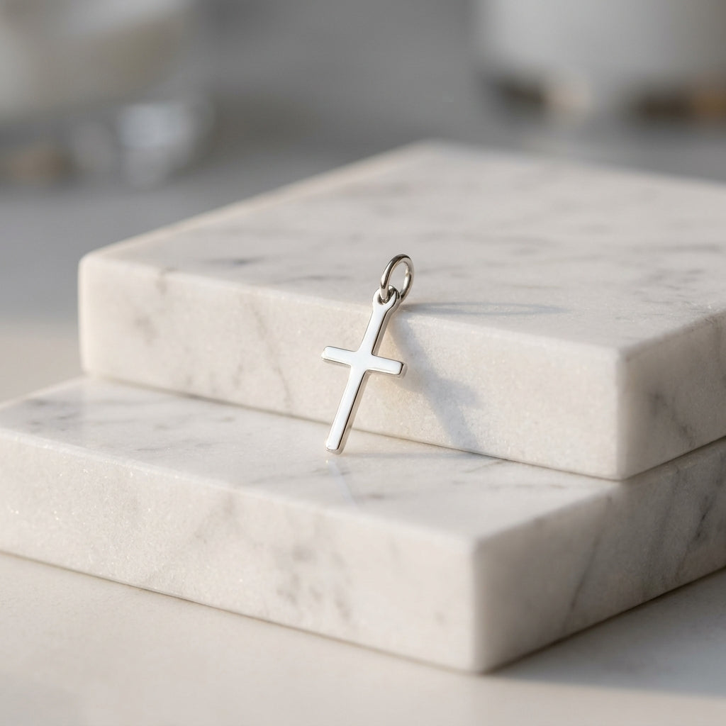Silberner Kreuz-Anhänger Spirit auf weißem Marmor, minimalistisches Design aus poliertem Echtsilber mit Öse