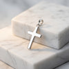 Silberner Kreuz-Anhänger Essence Moyen mit polierter Oberfläche auf weißen Marmorblöcken, hochglänzend aus 925er Sterlingsilb