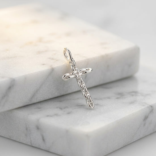 Silberner Kreuz-Anhänger mit Kettenmuster auf weißem Marmor, handgefertigt aus 925er Sterlingsilber