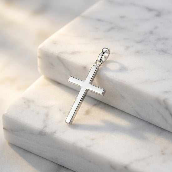 Silberner Kreuz-Anhänger Core Moyen mit polierter Oberfläche auf weißem Marmor, minimalistisches Design aus 925er Sterlingsil