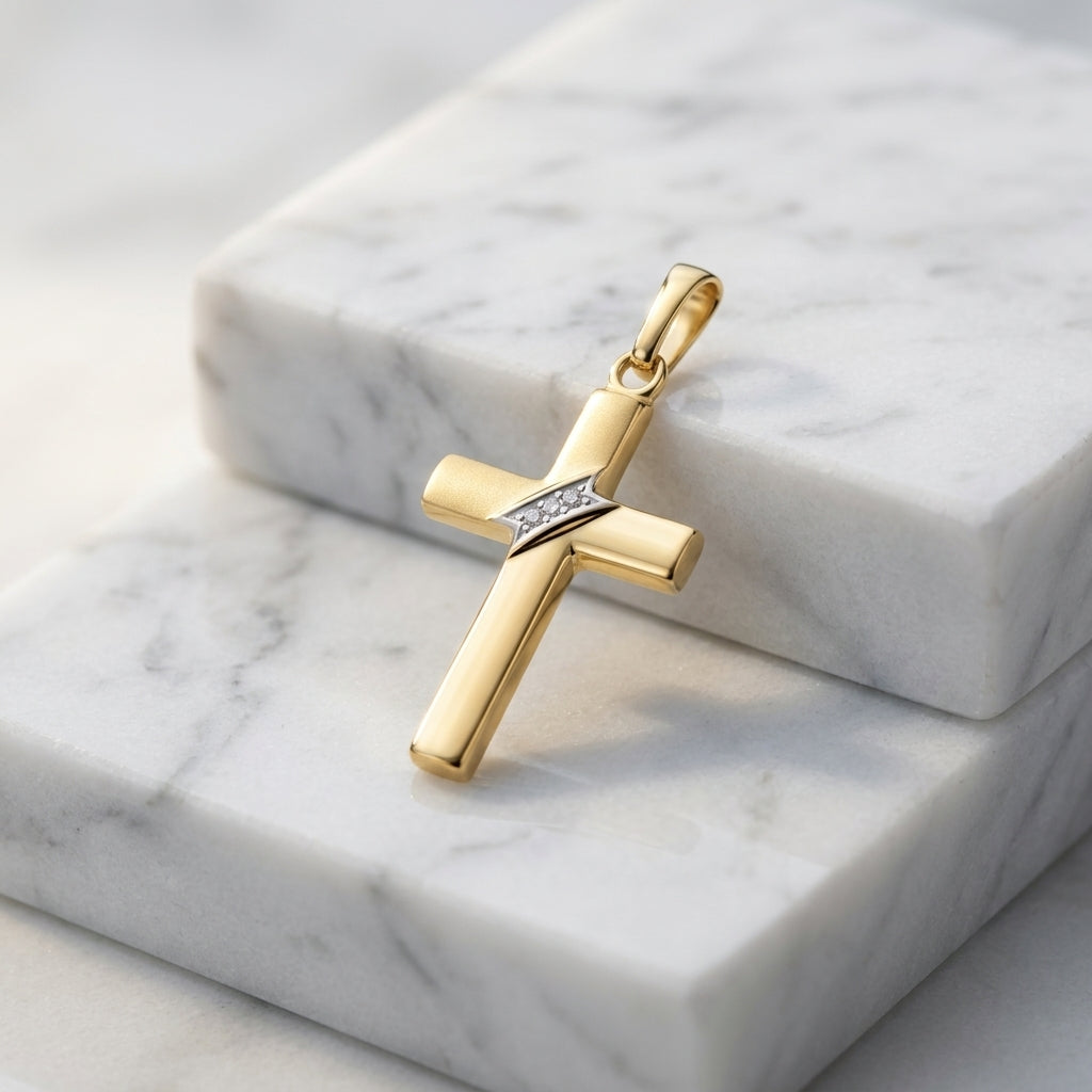Goldener Kreuz-Anhänger mit diagonalem Band, polierte Oberfläche, auf weißem Marmor präsentiert