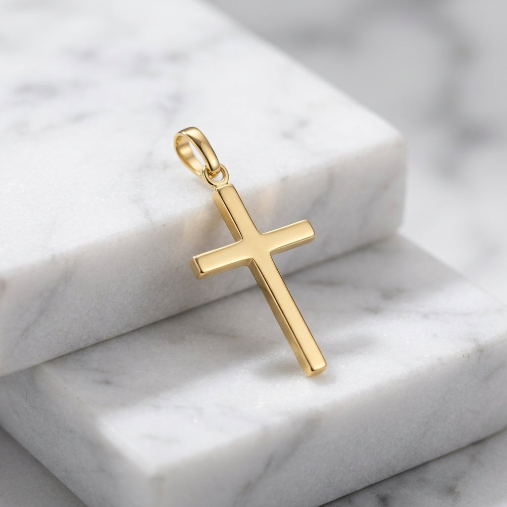 Goldener Kreuz-Anhänger Glory aus massivem Edelmetall mit polierter Oberfläche auf weißem Marmor