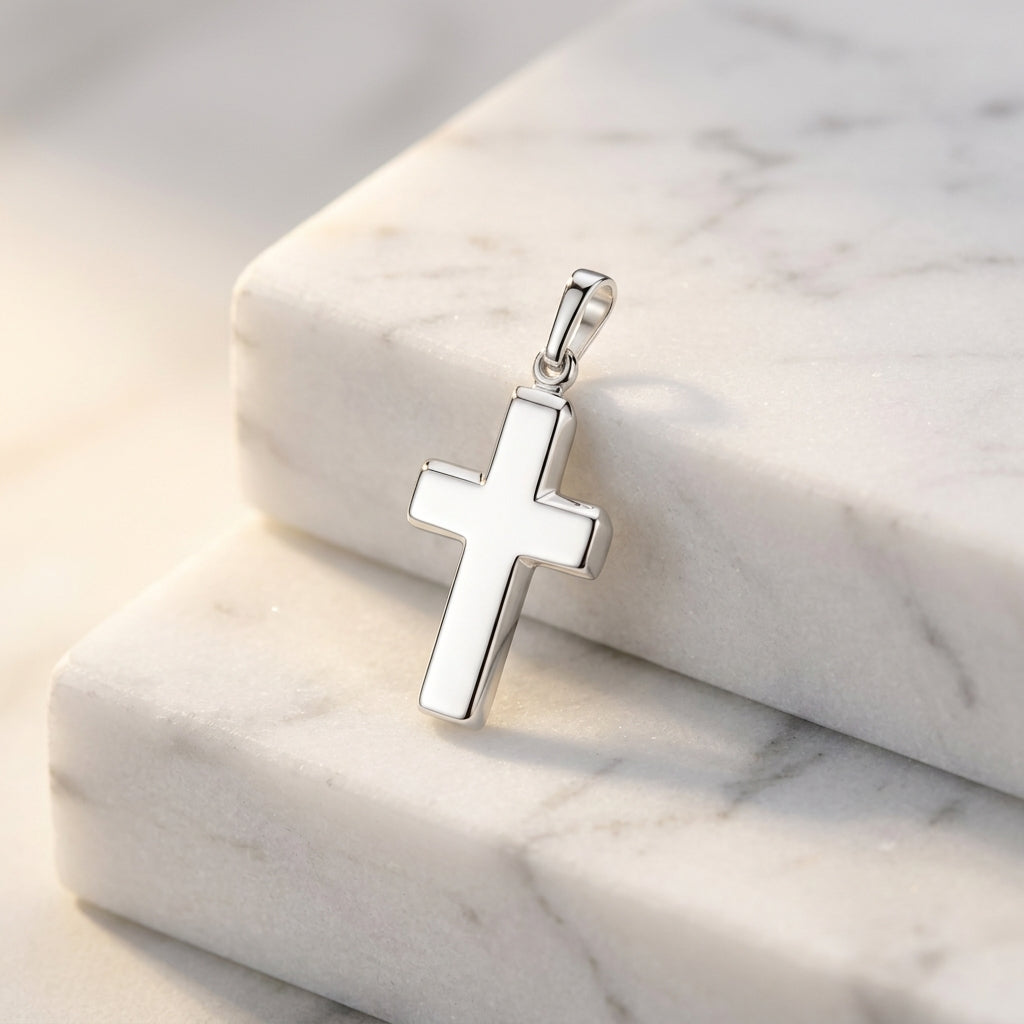 Silberner Kreuz-Anhänger King mit polierter Oberfläche auf weißem Marmor, schlichte Form aus 925er Sterlingsilber