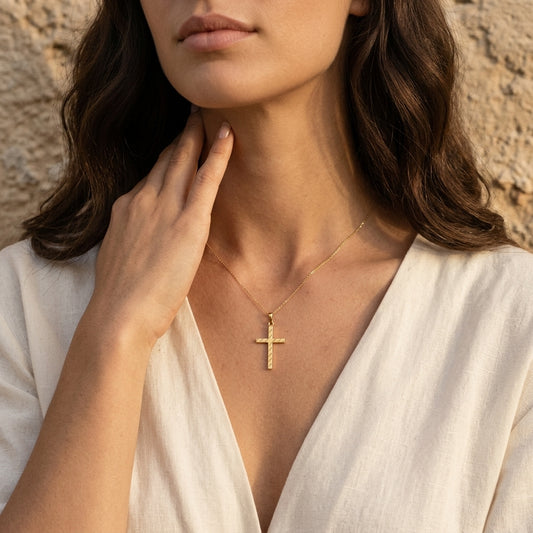 Frau trägt goldenen Kreuz-Anhänger Light an filigraner Kette, handgefertigt aus Echtgold von Aurevia Manufaktur