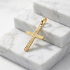 Goldener Kreuz-Anhänger Liné mit gerillter Oberfläche auf weißen Marmorblöcken, 18 Karat Gelbgold