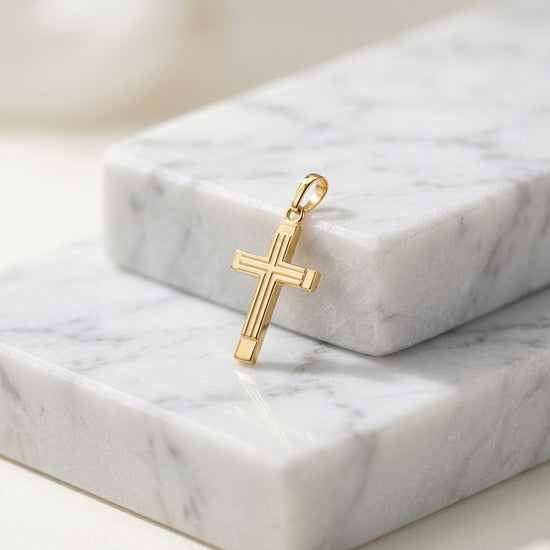 Goldener Kreuz-Anhänger Linea mit geometrischem Design auf weißem Marmor, 14 Karat Gold, Pforzheimer Handwerkskunst