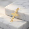 Goldener Kreuz-Anhänger Ray mit diagonaler Rillenstruktur auf weißem Marmor, echtes Gold aus Pforzheim