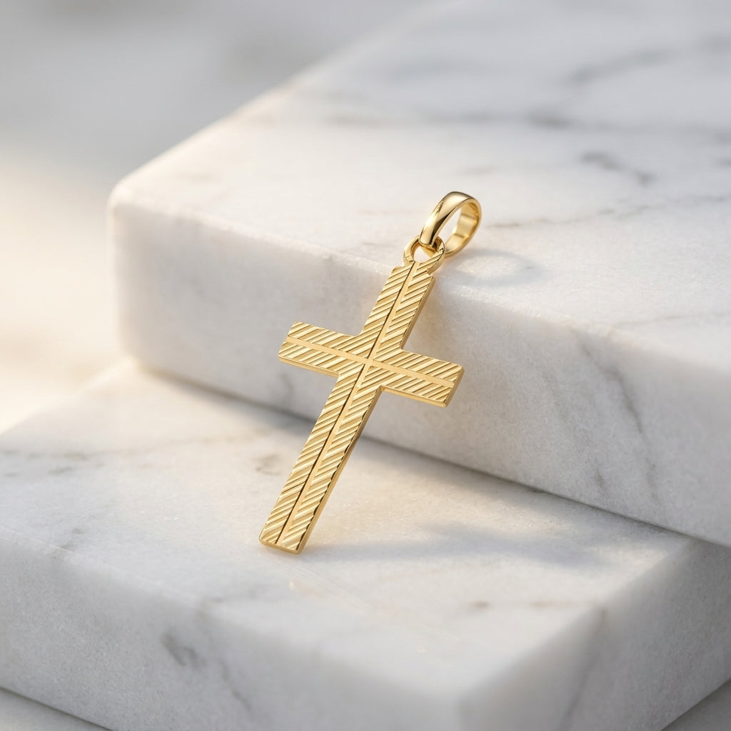 Goldener Kreuz-Anhänger Ray mit diagonaler Rillenstruktur auf weißem Marmor, echtes Gold aus Pforzheim