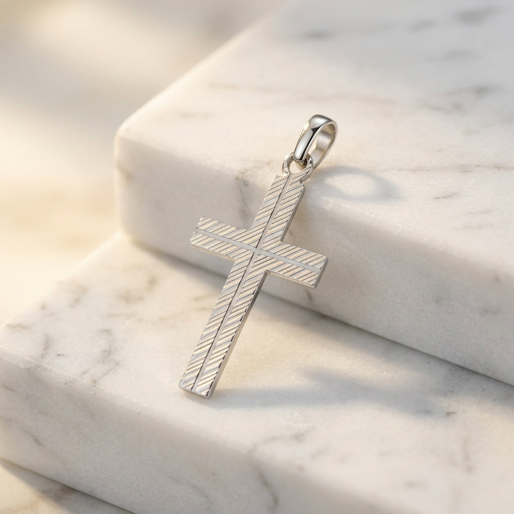 Silberner Kreuz-Anhänger Ray mit diagonaler Linienstruktur auf weißem Marmor, handgefertigt aus 925er Sterlingsilber