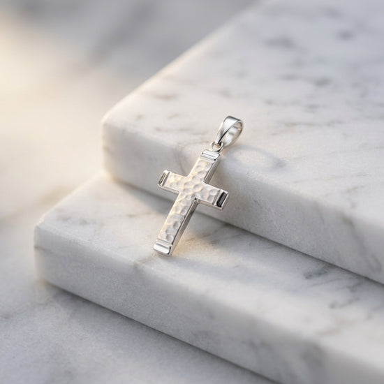 Silberner Kreuz-Anhänger Reed mit weißem Perlmutt-Inlay auf weißem Marmor, Edelstahl-Details an den Enden