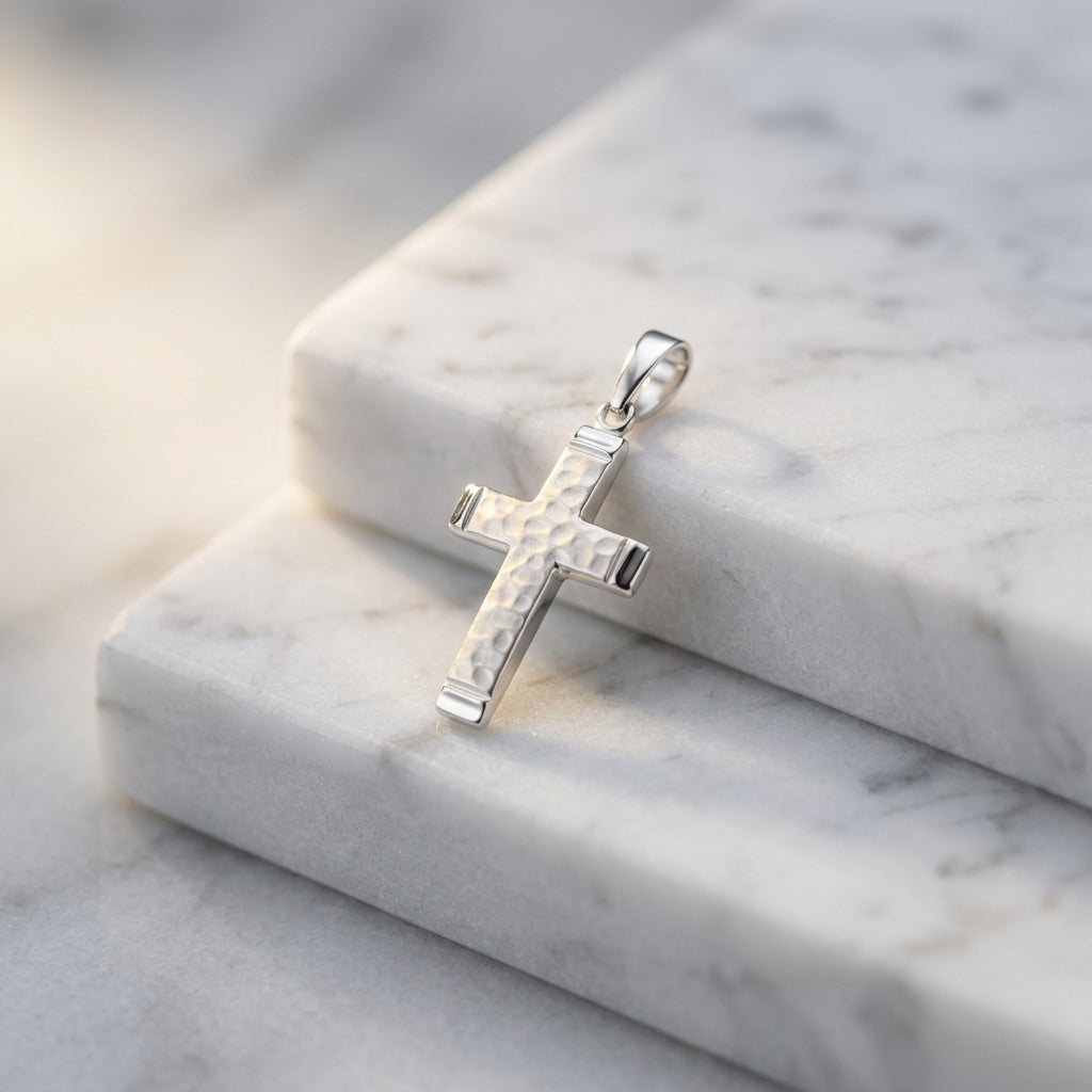 Silberner Kreuz-Anhänger Reed mit weißem Perlmutt-Inlay auf weißem Marmor, Edelstahl-Details an den Enden