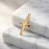 Goldener Kreuz-Anhänger mit geometrischem Muster auf weißem Marmor, hochglanzpoliert mit Öse zum Anhängen