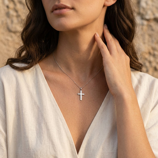 Silberner Kreuz-Anhänger Salvation an filigraner Kette, getragen von Frau in weißer Bluse