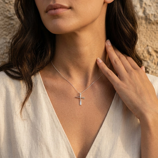 Frau trägt silbernen Kreuz-Anhänger Twist an feiner Kette, gedrehtes Design, Edelmetall-Schmuck von Aurevia Manufaktur