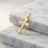 Goldener Kreuz-Anhänger Vector mit eingefrästem Kreuz-Muster auf weißem Marmor, 585er Gelbgold