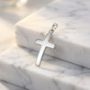 Silberner Kreuz-Anhänger Velvet mit glänzend polierter Oberfläche auf weißem Marmor