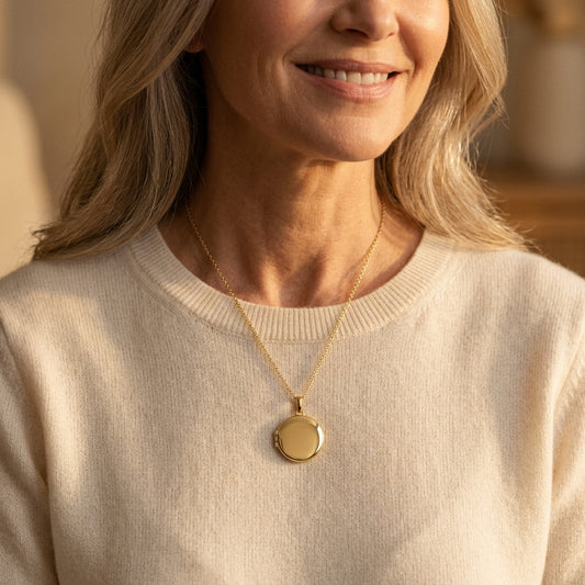 Frau trägt goldenes rundes Medaillon Luna an filigraner Kette über beigem Pullover, Aurevia Manufaktur
